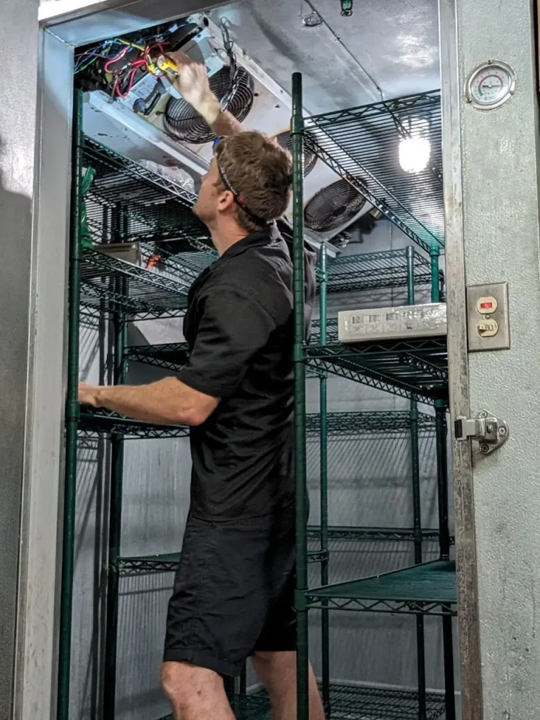 Cactus Appliance technician servicing the evaporator fans inside a walk-in cooler in Orange County