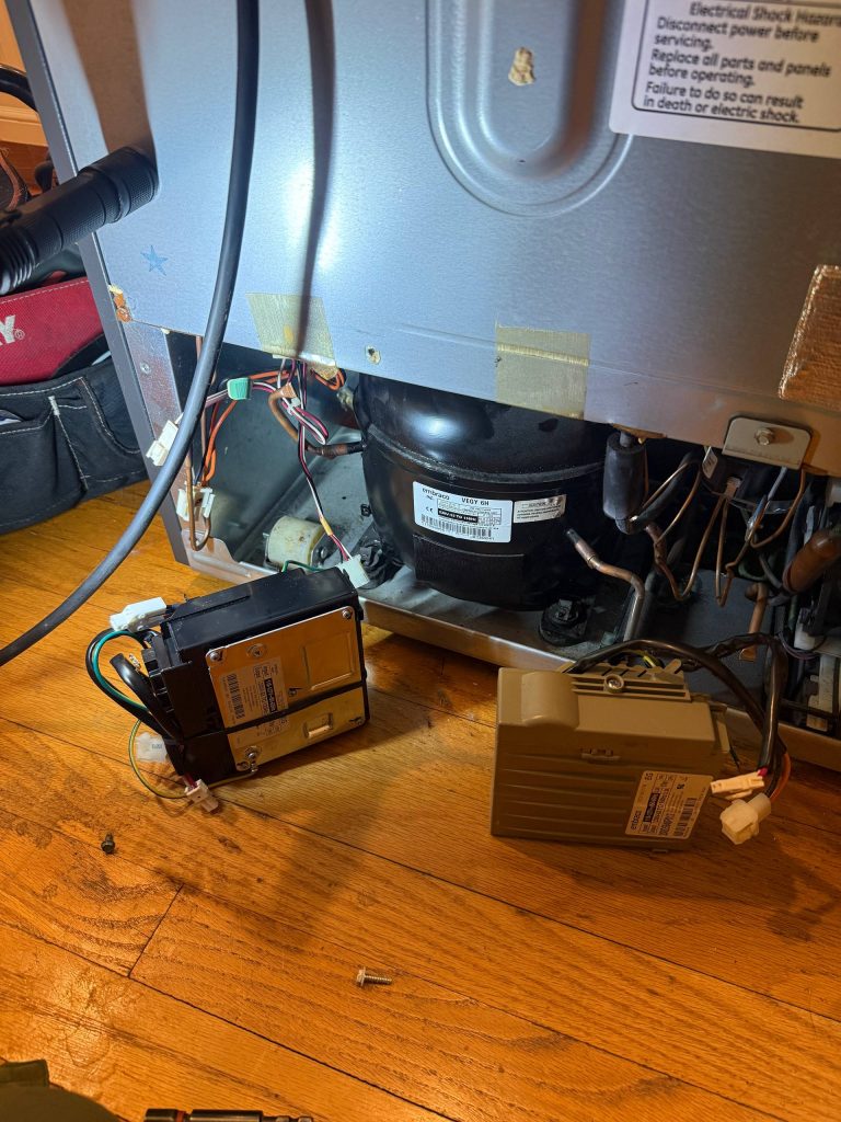 GE refrigerator with the inverter board exposed during a no-cooling repair in Orange County